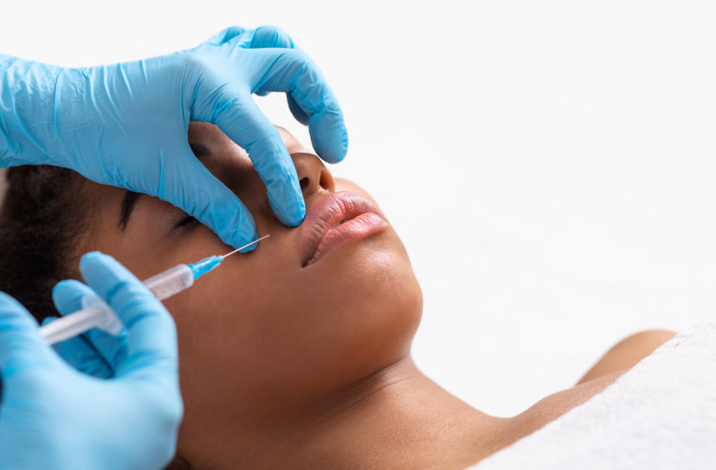 Mulher recebe aplicação de toxina botulínica em harmonização facial