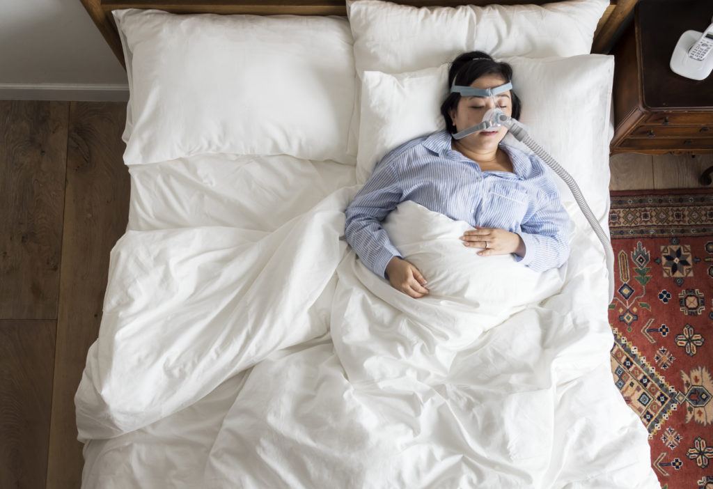 Paciente utilizando CPAP, um aparelho da Odontologia do Sono que ajuda na apneia