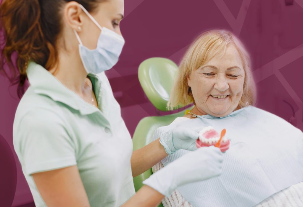 Dentista apresentando à paciente meios para cuidar de sua prótese dentária.